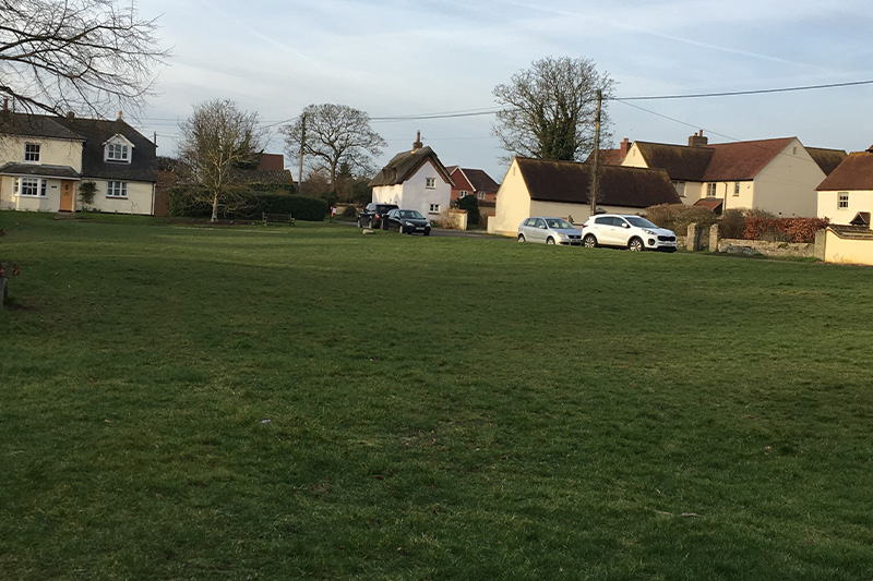 townsend green with thatched house in background